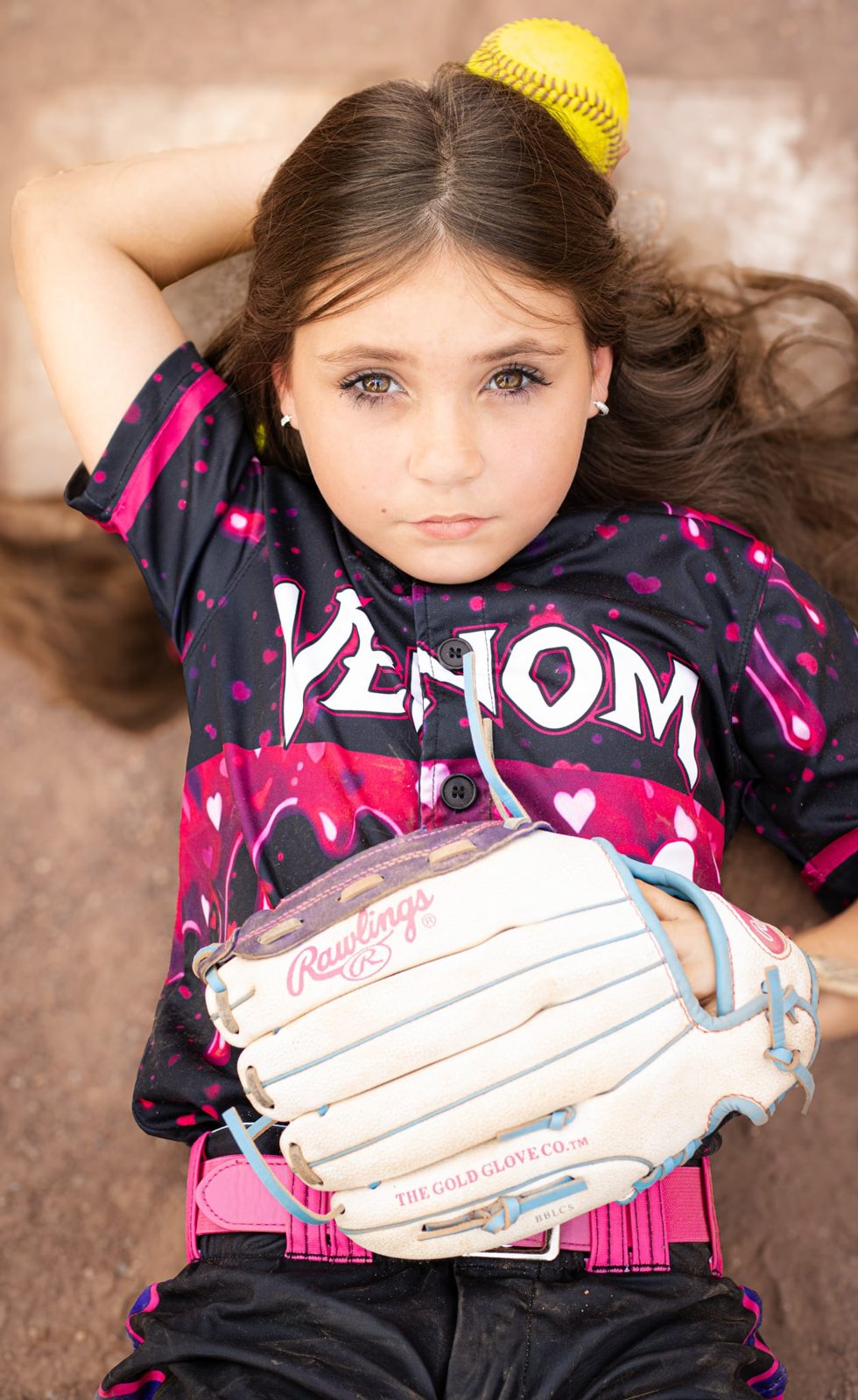 Young softball player resting with her glove