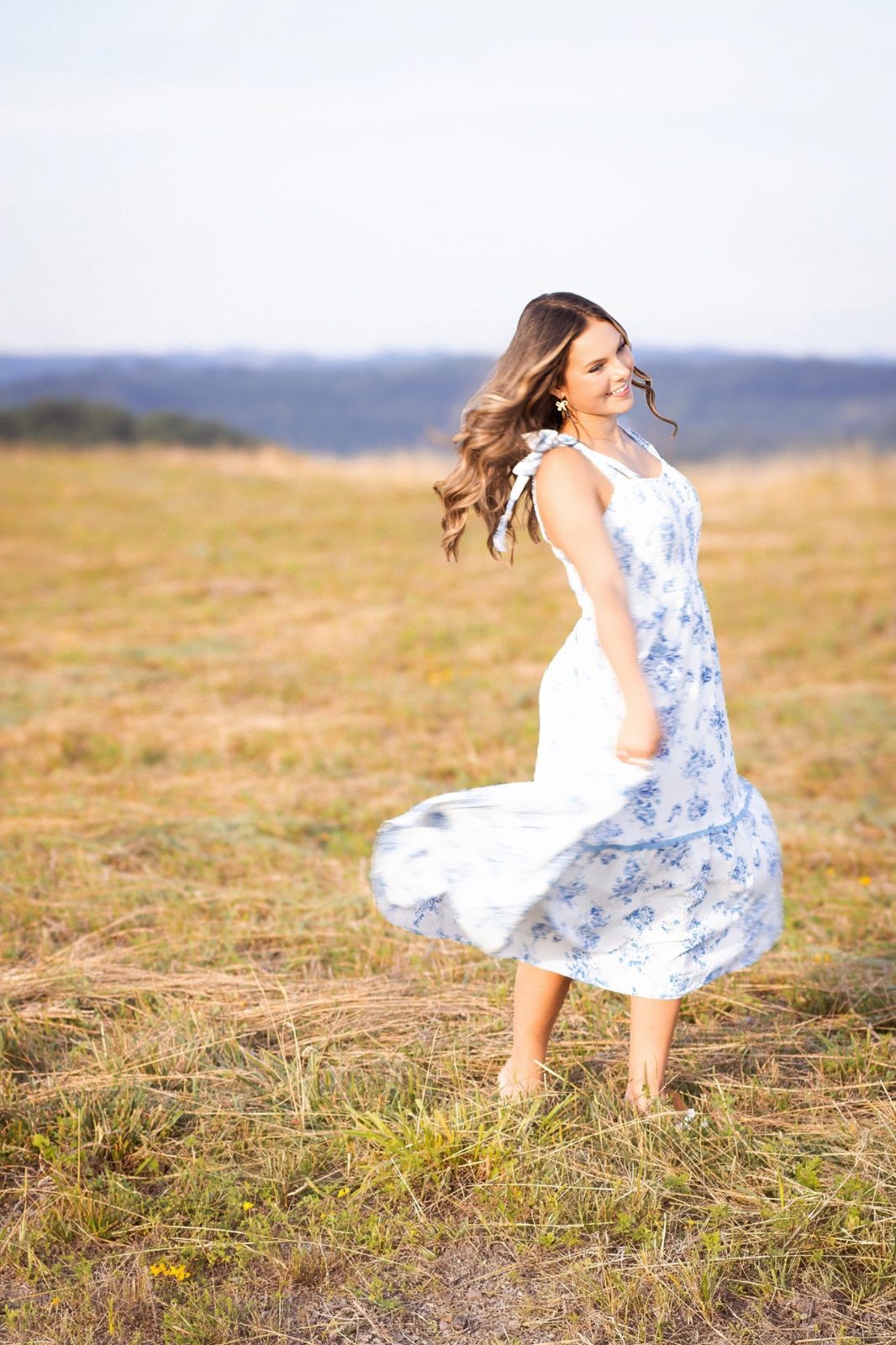 A girl twirling in a golden Kentucky field at sunset