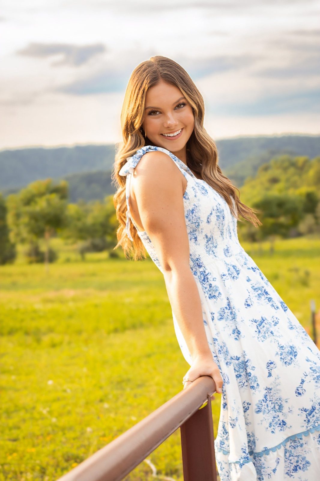 Senior on a fence in a golden field