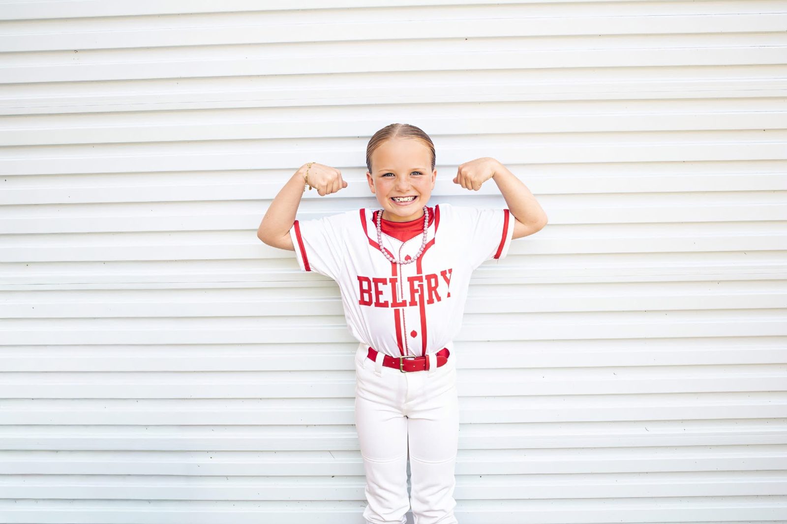Little ballplayer flexing in a Belfry uniform